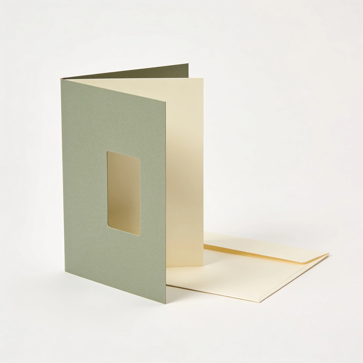 Window Reveal Card — sage die-cut window front with separate cream inner panel; cream envelope